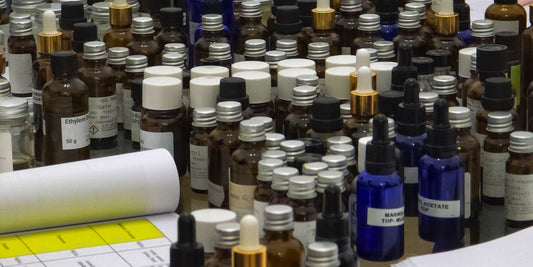 A perfume being made, with a lot of essential oils on the table and a digital scale